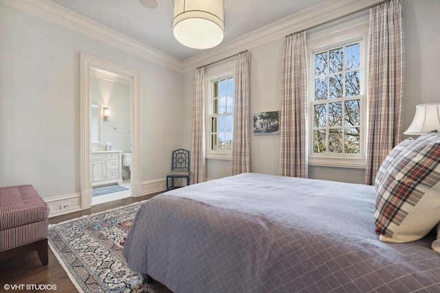 bedroom featuring hardwood / wood-style flooring, crown molding, and connected bathroom