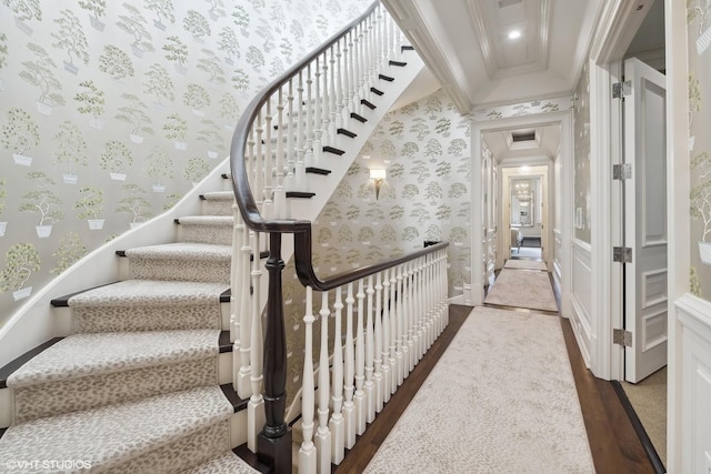 staircase with crown molding and hardwood / wood-style flooring