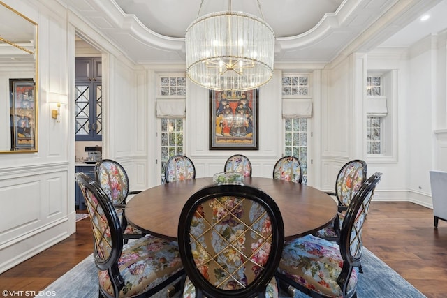 dining room featuring a raised ceiling, dark hardwood / wood-style flooring, crown molding, and a chandelier