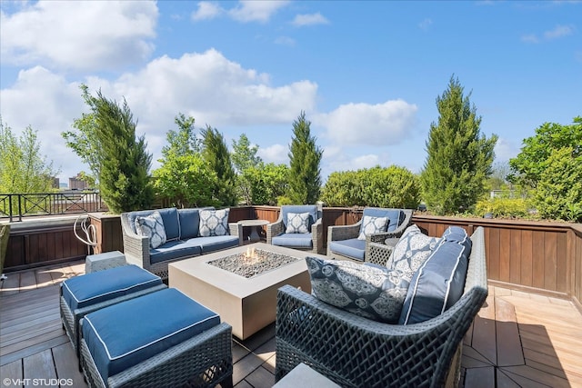 wooden deck featuring an outdoor living space with a fire pit