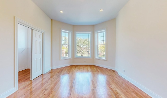 unfurnished bedroom with light hardwood / wood-style floors and a closet