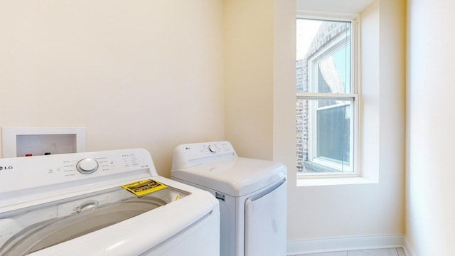 clothes washing area featuring tile patterned flooring and washer and dryer