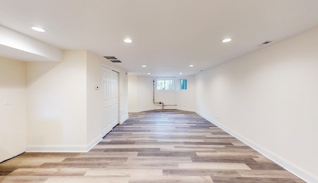 basement with light hardwood / wood-style flooring