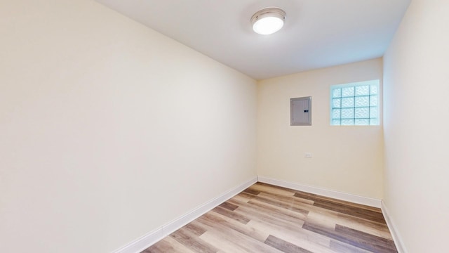 empty room with electric panel and light hardwood / wood-style flooring