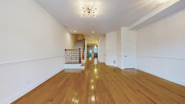 hall with a notable chandelier and light wood-type flooring