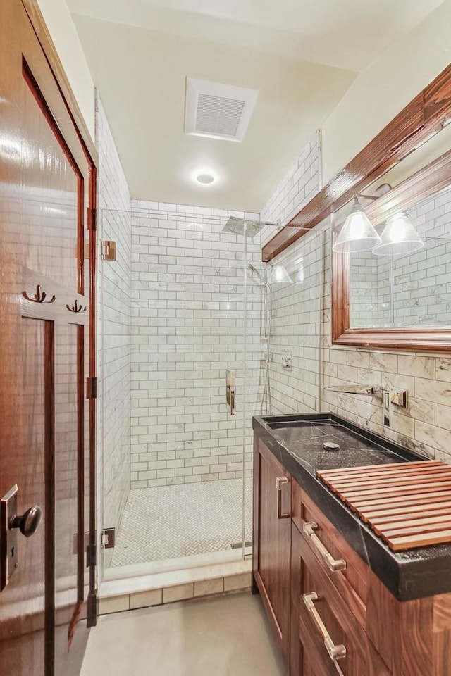 full bathroom featuring a stall shower, visible vents, and vanity