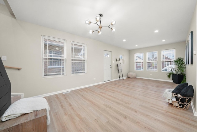 living area with light hardwood / wood-style floors and a notable chandelier