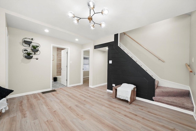 unfurnished living room with light hardwood / wood-style flooring and a chandelier