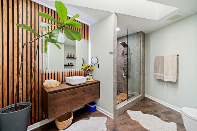 bathroom with hardwood / wood-style floors, vanity, a shower with door, and toilet