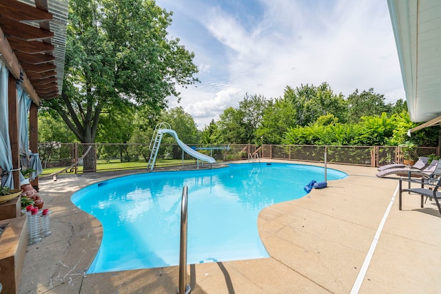 view of pool with a water slide and a patio