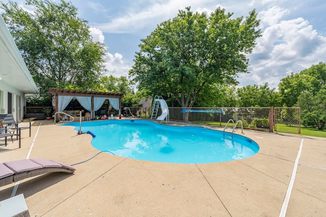 view of pool with a water slide and a patio