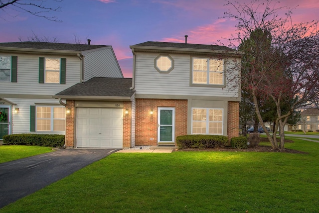 front of property with a lawn and a garage