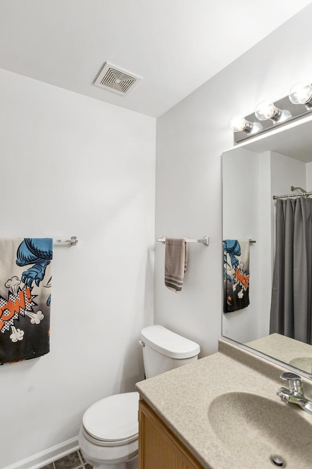 bathroom with tile patterned flooring, vanity, and toilet