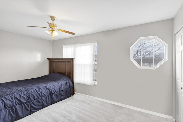 bedroom with multiple windows, ceiling fan, and light carpet