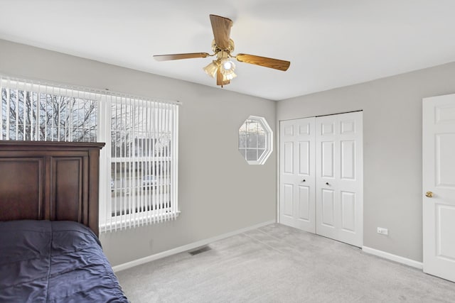 unfurnished bedroom with multiple windows, ceiling fan, a closet, and light colored carpet