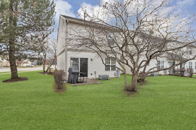 rear view of house featuring a yard, a patio, and central air condition unit