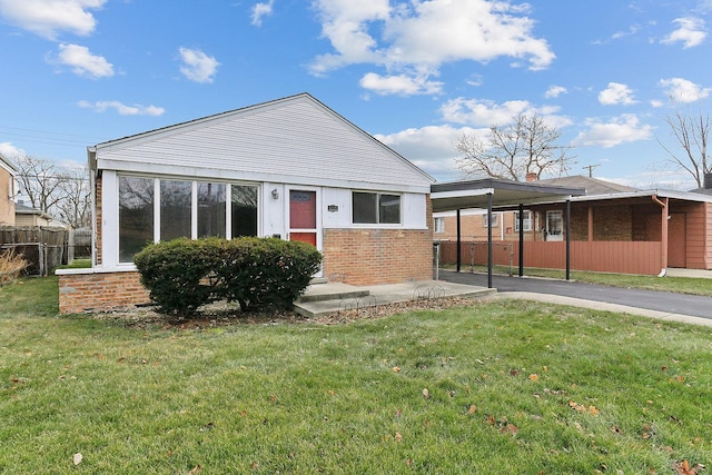 view of front of property featuring a front lawn and a carport