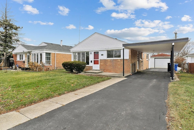 view of front of home with a front yard, a carport, and an outdoor structure