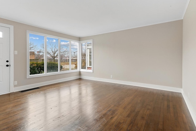 unfurnished room featuring wood-type flooring and crown molding