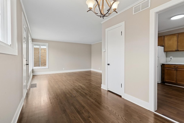 interior space with crown molding, dark hardwood / wood-style flooring, and an inviting chandelier