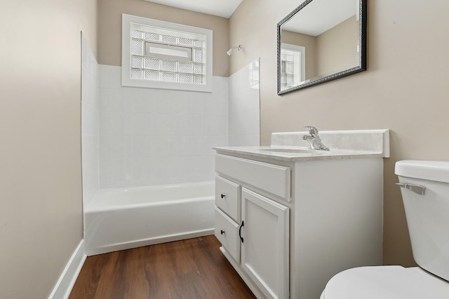 full bathroom featuring toilet, plenty of natural light, vanity, and hardwood / wood-style flooring