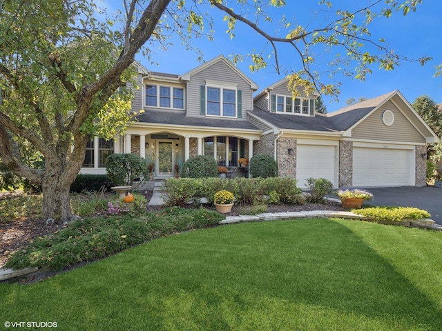 view of front facade featuring covered porch, a garage, and a front yard