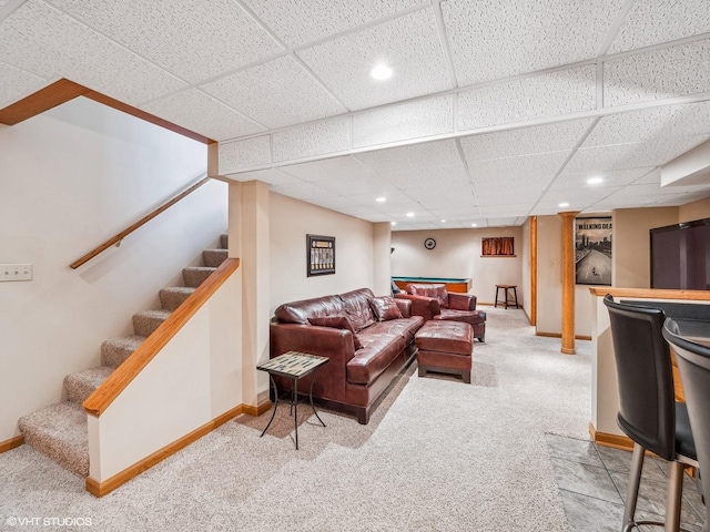 living room with carpet flooring and a paneled ceiling