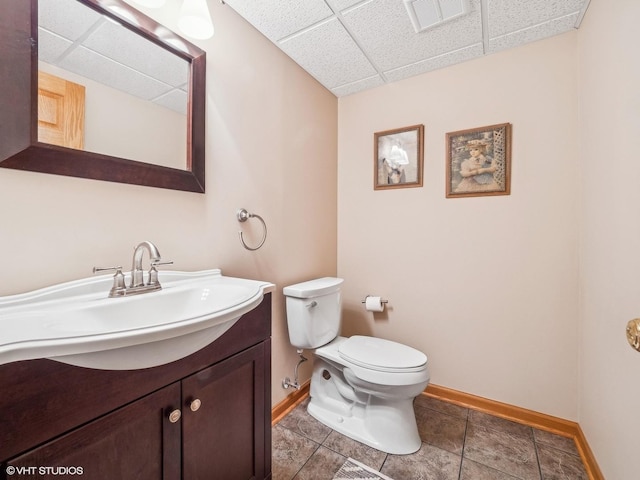 bathroom featuring a paneled ceiling, vanity, and toilet