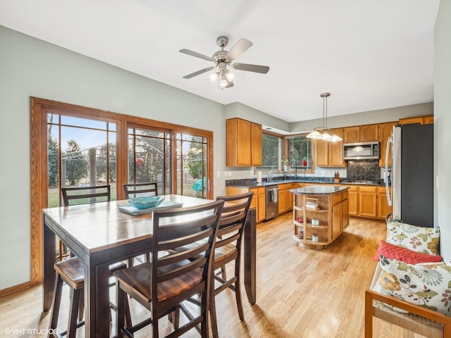 dining space with light hardwood / wood-style floors and ceiling fan