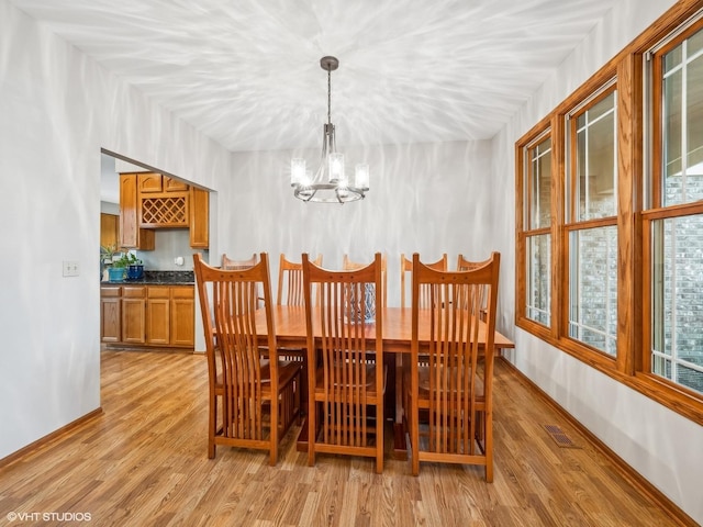 dining area featuring light hardwood / wood-style flooring and a notable chandelier