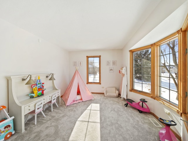 recreation room featuring light colored carpet and plenty of natural light