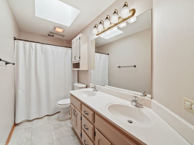 bathroom with a skylight, tile patterned floors, vanity, and toilet