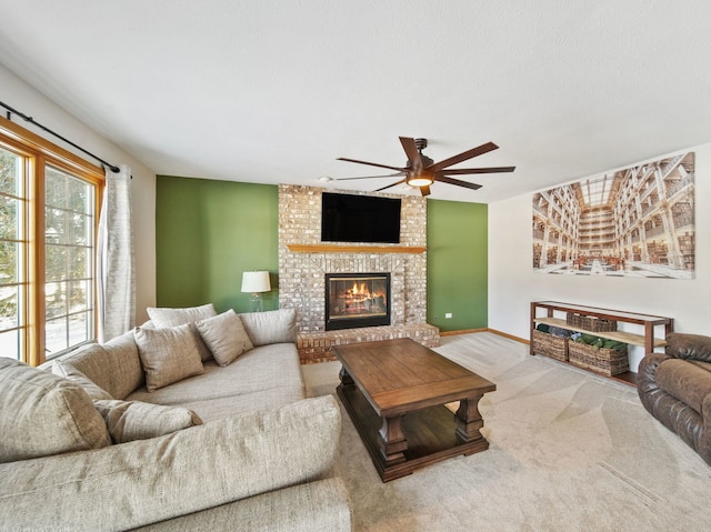 carpeted living room with a fireplace and ceiling fan