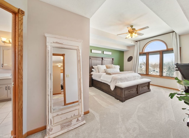 tiled bedroom featuring ensuite bath and ceiling fan