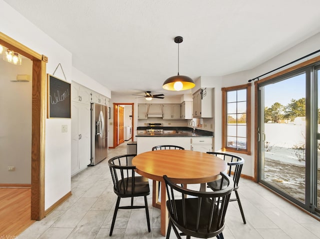 dining space featuring sink and ceiling fan