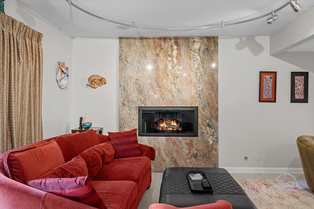 tiled living room featuring track lighting and a fireplace