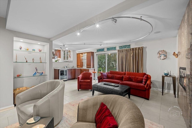 tiled living room featuring track lighting, wine cooler, and sink