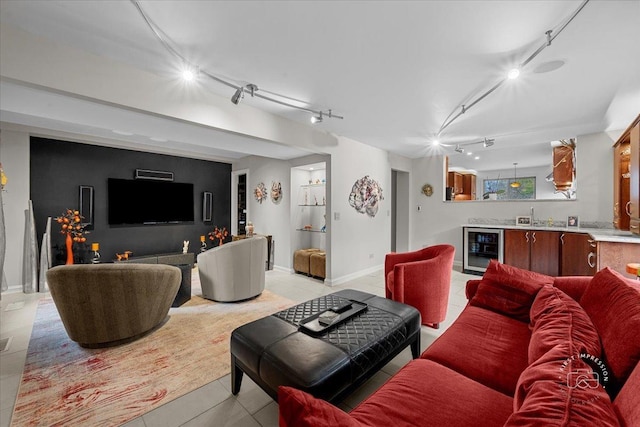 living room with light tile patterned floors, indoor bar, track lighting, and wine cooler