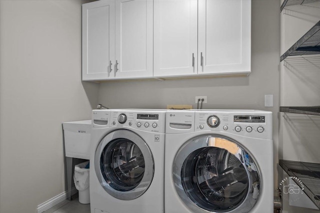 laundry room featuring separate washer and dryer and cabinets