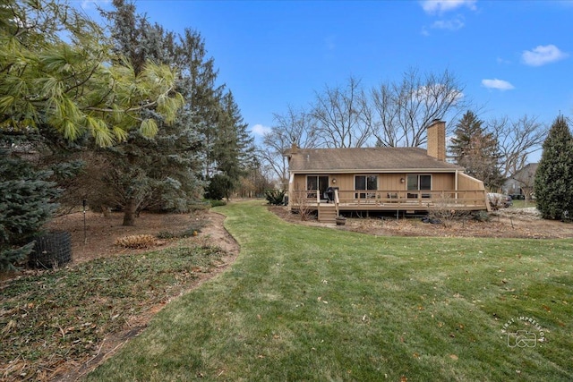 rear view of property featuring a yard and a wooden deck