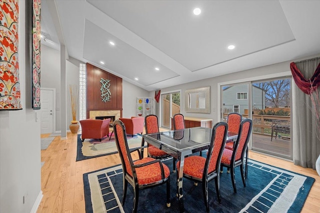 dining space with a large fireplace and light hardwood / wood-style flooring