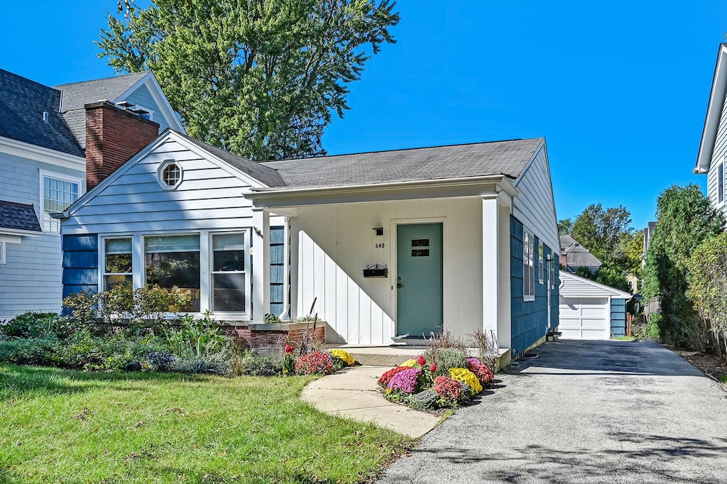 view of front facade with an outbuilding, a garage, and a front yard