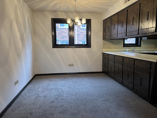 unfurnished dining area with a textured ceiling, light carpet, and an inviting chandelier