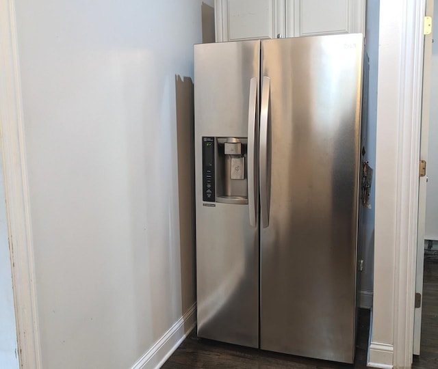 details with white cabinets, stainless steel fridge with ice dispenser, and dark wood-type flooring