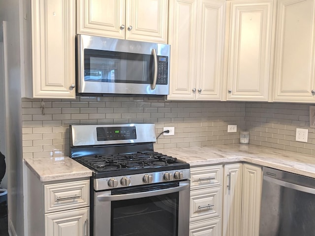 kitchen with decorative backsplash, light stone counters, and appliances with stainless steel finishes