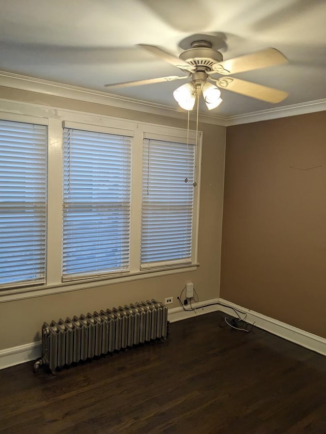 empty room featuring radiator, ceiling fan, dark hardwood / wood-style flooring, and ornamental molding