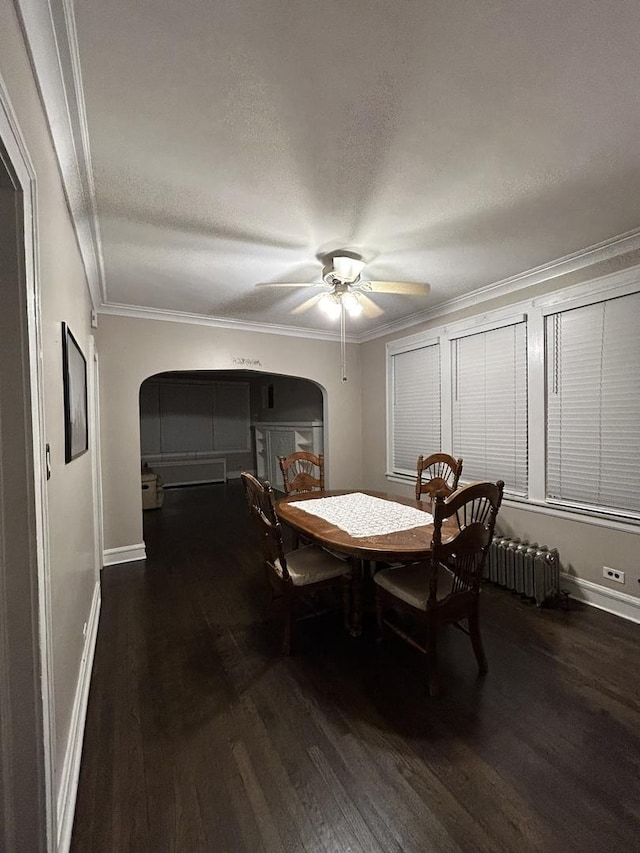 dining space with dark hardwood / wood-style flooring, radiator, a textured ceiling, ceiling fan, and crown molding