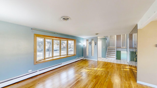 spare room featuring a baseboard radiator and light hardwood / wood-style flooring