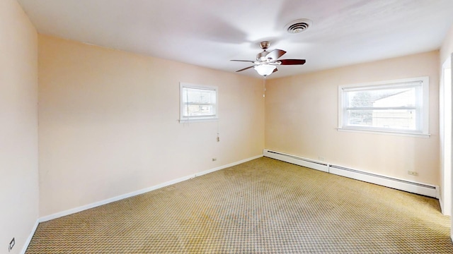 spare room with ceiling fan, carpet, and a baseboard heating unit