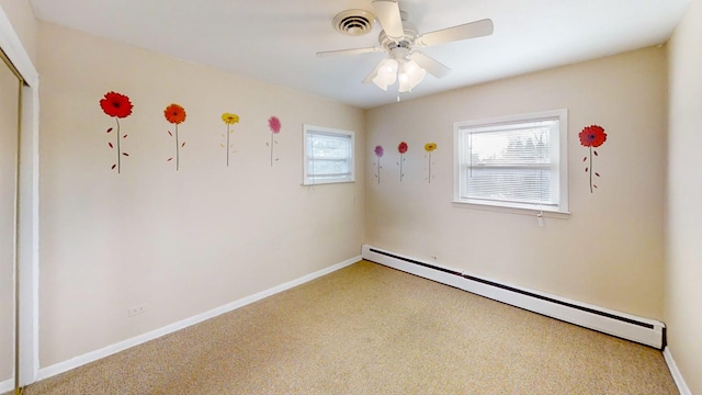 spare room with carpet flooring, plenty of natural light, ceiling fan, and baseboard heating